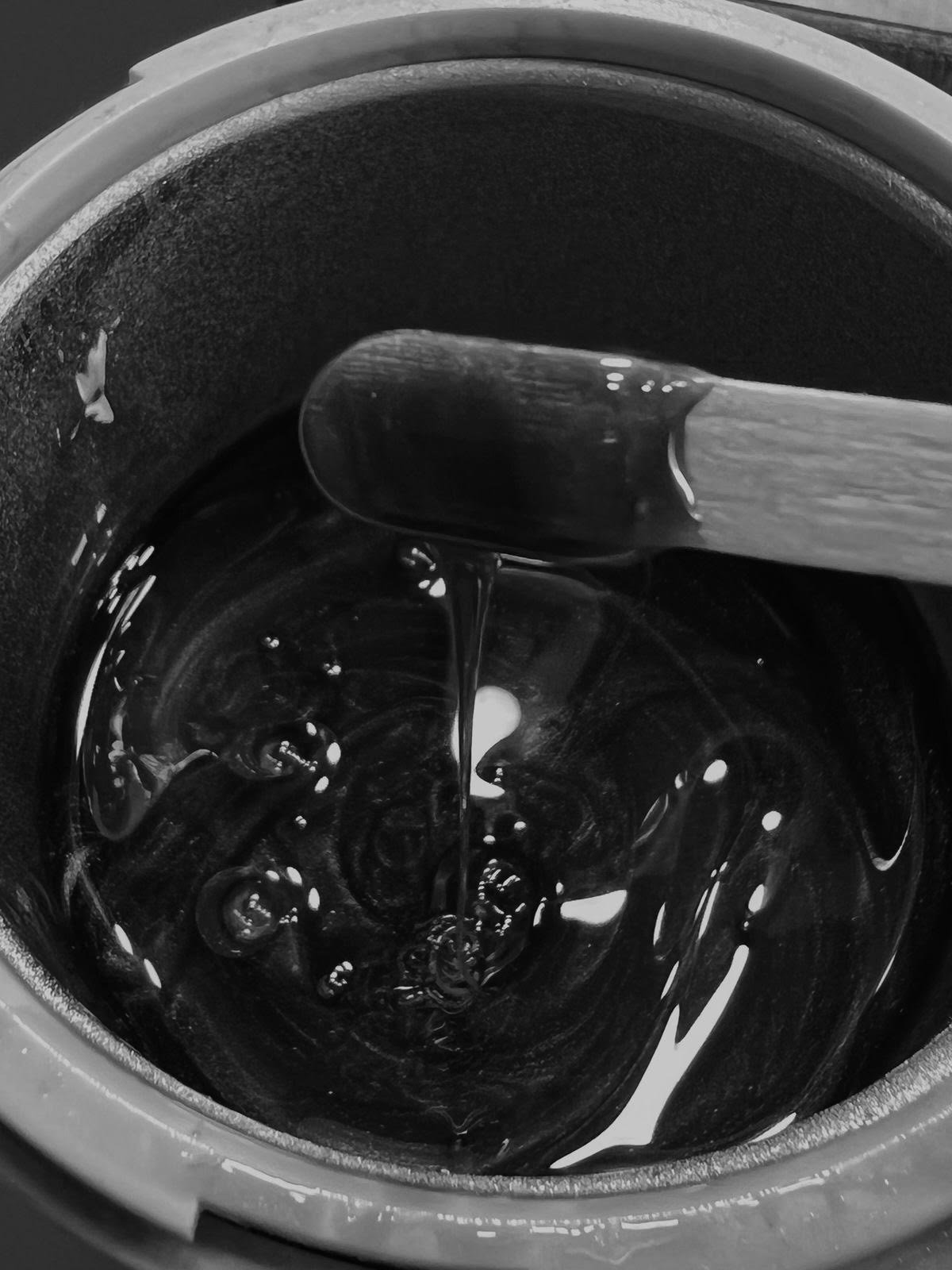 Warm wax being stirred in a wax pot